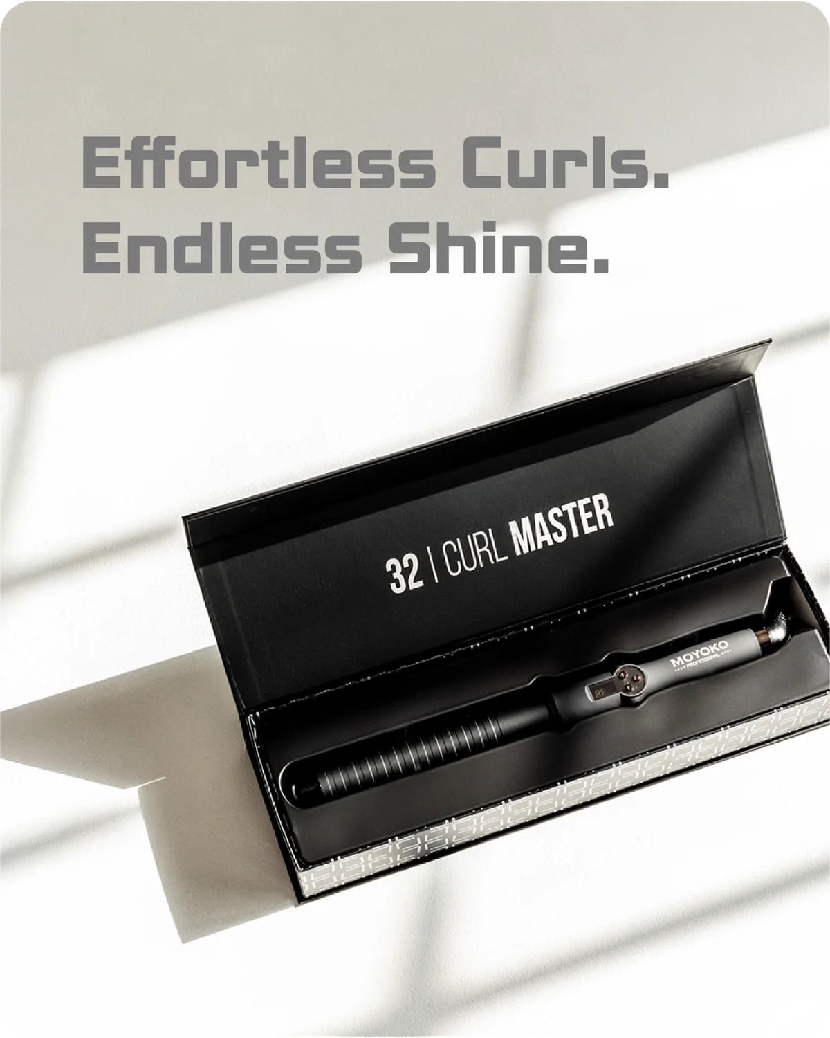 Curling iron in a black box with '32 Curl Master' branding on a light background.
