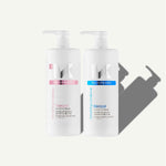 Two white pump bottles of Keraxir haircare products on a light gray background, one with a pink label and one with a blue label.
