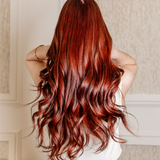 woman with back to camera, her red long hair is shinny and gorgeous as she uses kroma color 