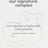 Skincare sheet mask with 'our signature complex' and 'our signature hyaluronic acid solution' text on a light gray background.