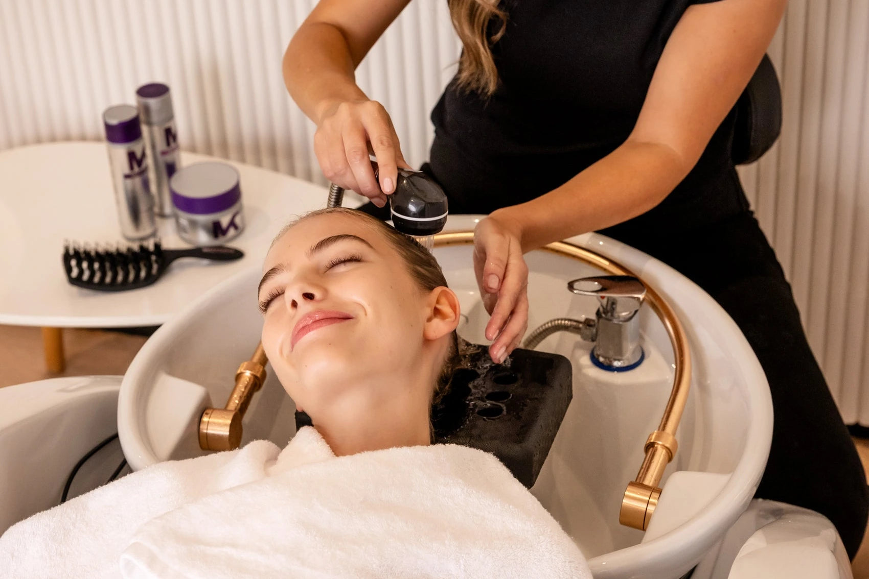 lady having her hair washed with tone and treat products at the salon basin 