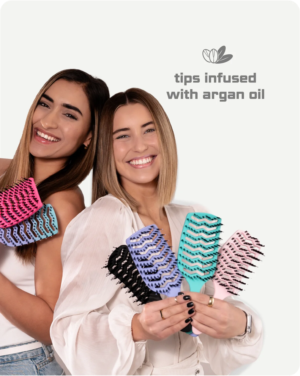 Two women holding colorful hairbrushes with 'tips infused with argan oil' text on a white background.