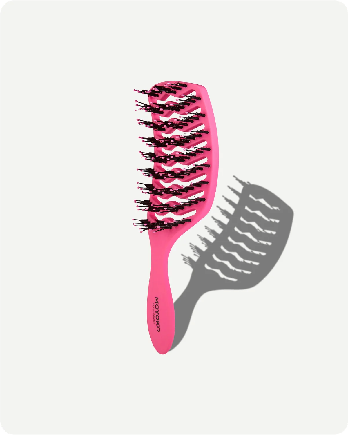 Pink hairbrush with black bristles on a white background