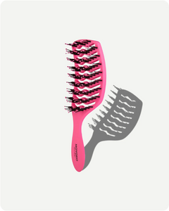 Pink hairbrush with black bristles on a white background