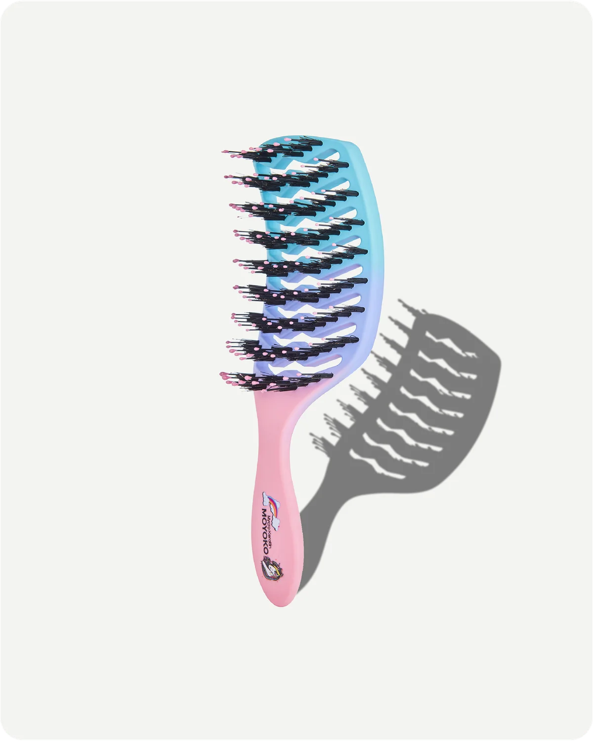 Gradient hairbrush with pink handle and blue bristle head on a white background