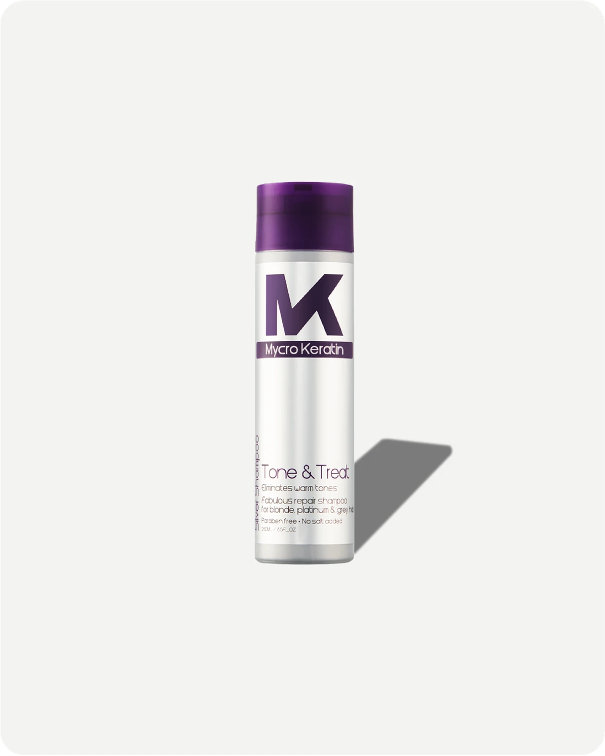 Tone & Treat shampoo bottle with purple cap and white label on a light gray background
