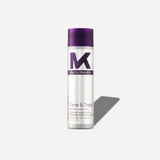 Tone & Treat shampoo bottle with purple cap and white label on a light gray background