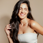 Woman smiling with long, shinny and well groomed dark hair 